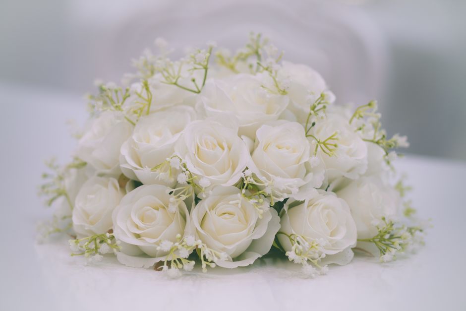 Bouquet de roses blanches avec des fleurs délicates, idéal pour décorer une table de fête élégante.