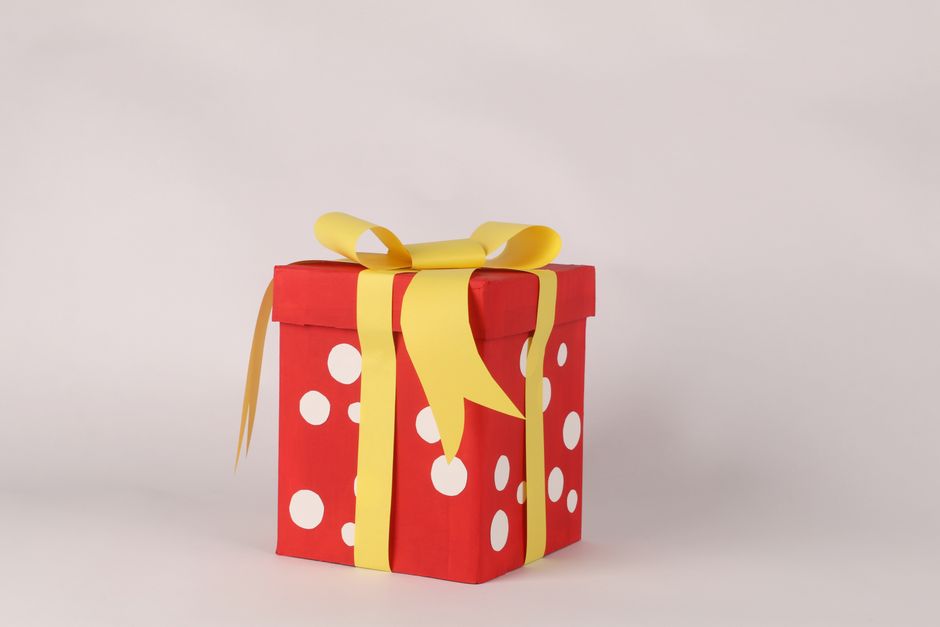 Cadeau rouge à pois blancs avec un ruban jaune, symbolisant l'effet waouh d'un cadeau inattendu.