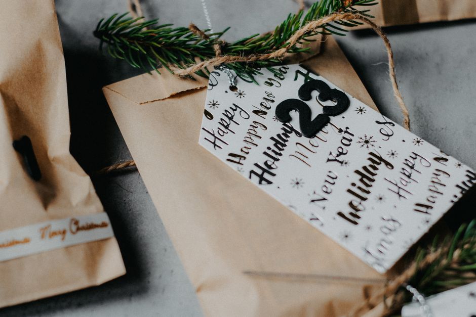 Cadeaux emballés dans du papier kraft avec une étiquette festive et une branche de sapin.