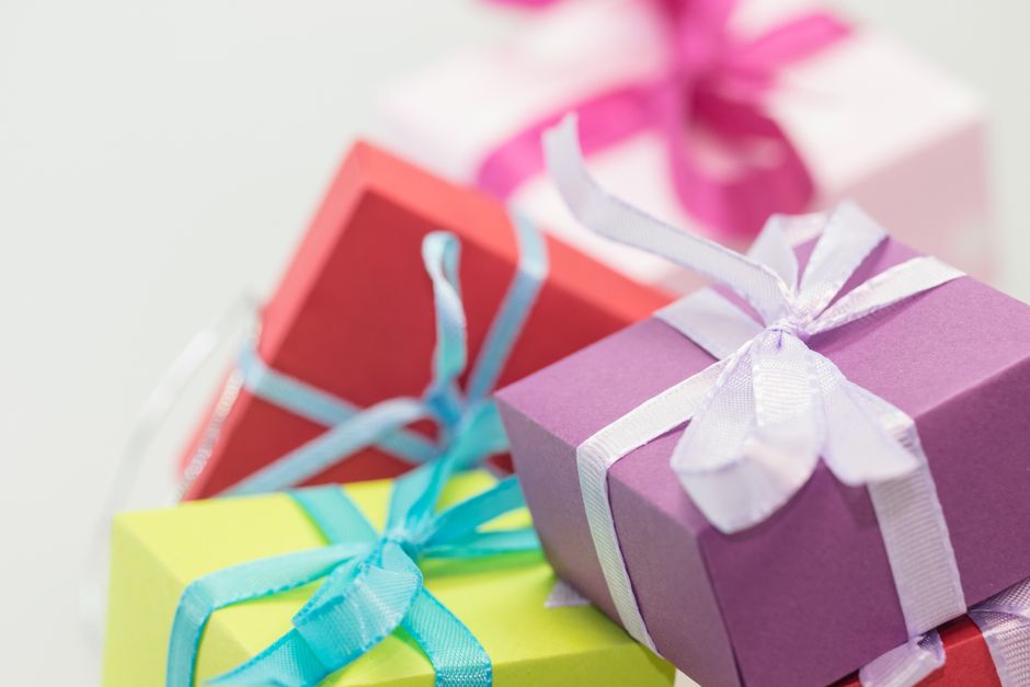 Cadeaux colorés empilés avec des rubans, symbolisant l'idée de cadeaux sensoriels et d'émotions.